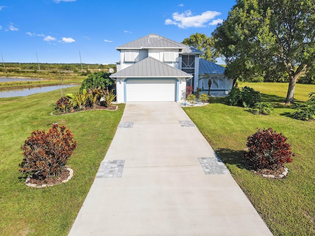 view of front of property with a water view, a garage, and a front lawn