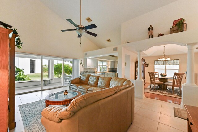 tiled living room featuring ceiling fan, sink, and a high ceiling