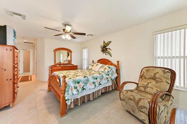 tiled bedroom with ceiling fan and access to exterior