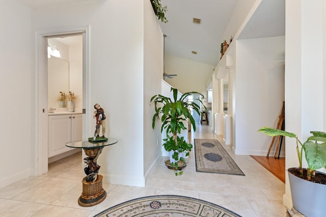 corridor featuring light tile patterned floors and decorative columns