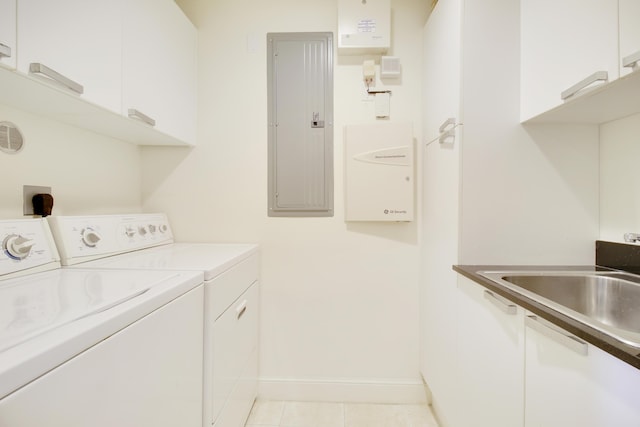 laundry room featuring washer and clothes dryer, cabinets, electric panel, sink, and light tile patterned flooring