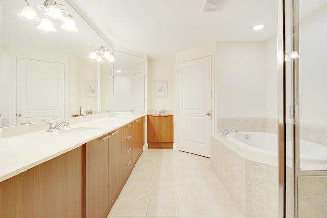 bathroom featuring tile patterned flooring, vanity, a relaxing tiled tub, and an inviting chandelier