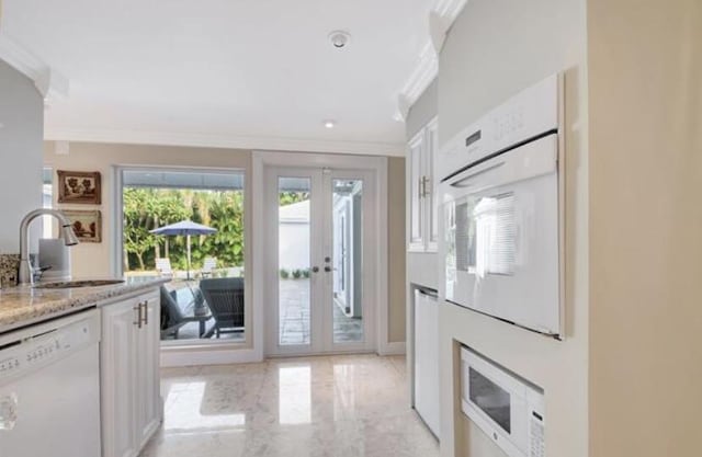 kitchen featuring french doors, ornamental molding, white appliances, sink, and white cabinets