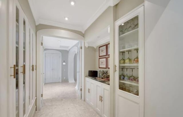 hall featuring light tile patterned floors and ornamental molding