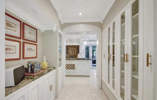 corridor with crown molding and light tile patterned flooring