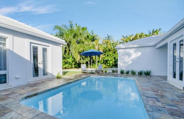 view of swimming pool featuring a patio area and french doors