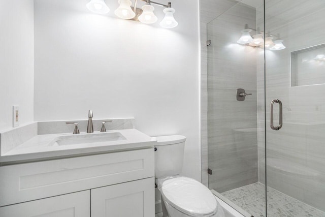 bathroom with an enclosed shower, vanity, and toilet