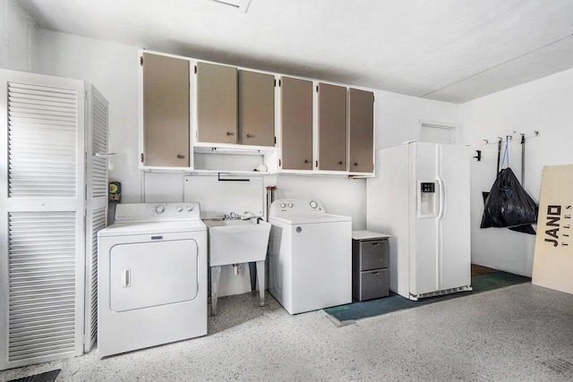 laundry area with cabinets, washing machine and dryer, and sink