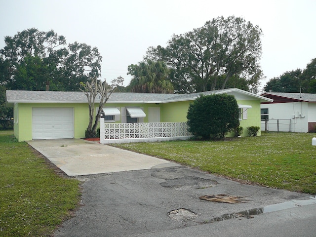 ranch-style home featuring a garage and a front lawn