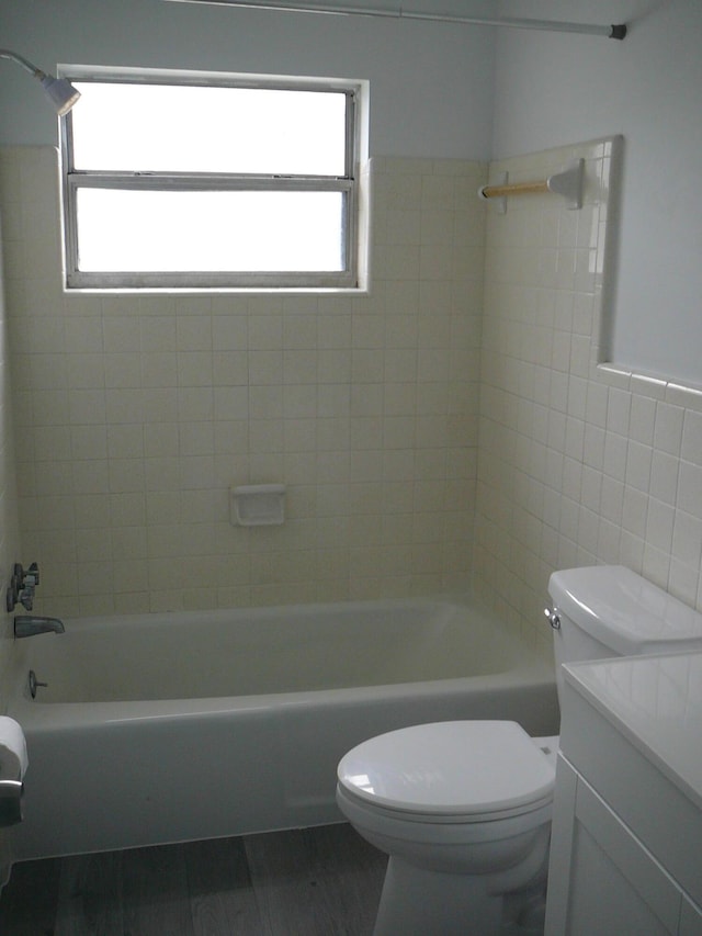 full bathroom with vanity, toilet, tile walls, and tiled shower / bath combo