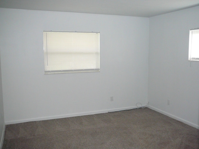 spare room with dark carpet