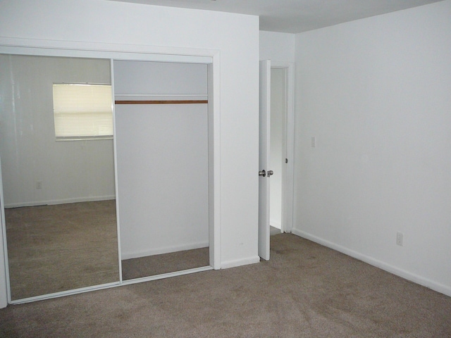 unfurnished bedroom with carpet floors and a closet