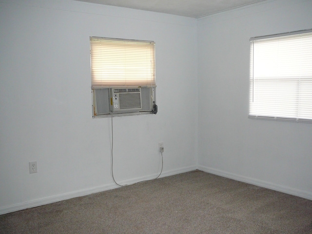 carpeted empty room featuring a wealth of natural light and cooling unit