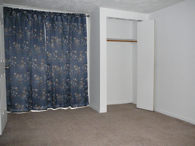 unfurnished bedroom featuring carpet and a textured ceiling