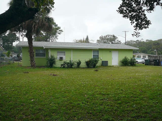 back of house with a lawn and cooling unit