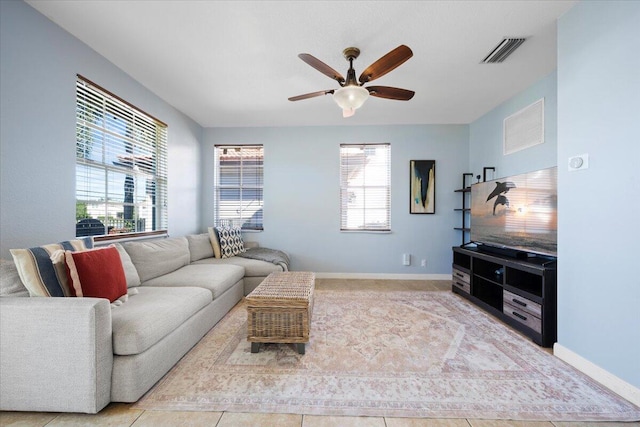 living room featuring a wealth of natural light, ceiling fan, and light tile patterned flooring