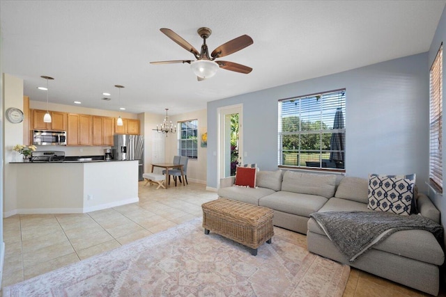 tiled living room featuring ceiling fan with notable chandelier