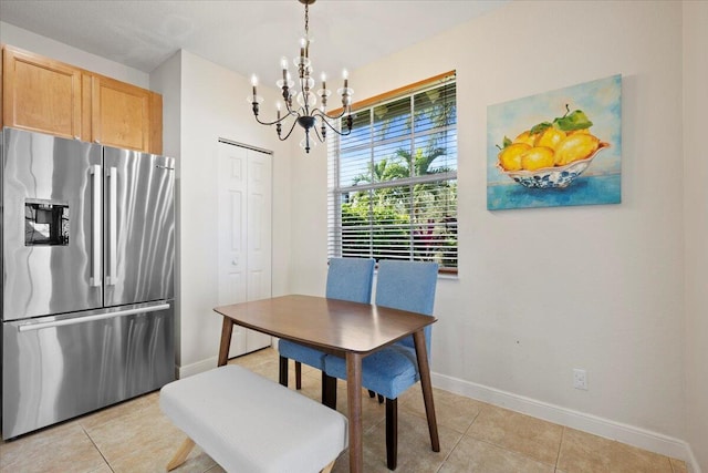 dining space featuring light tile patterned flooring and a notable chandelier