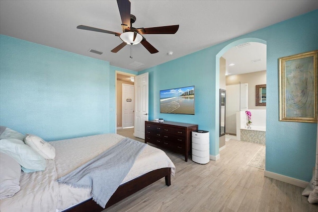 bedroom featuring ensuite bath, ceiling fan, and light wood-type flooring