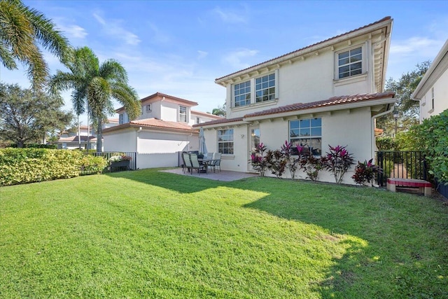 rear view of property featuring a patio and a lawn