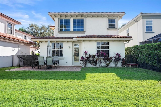 back of property featuring a patio and a lawn