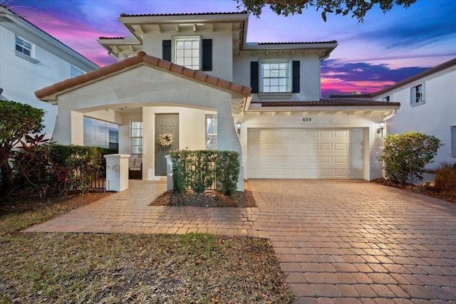 mediterranean / spanish-style house with a garage