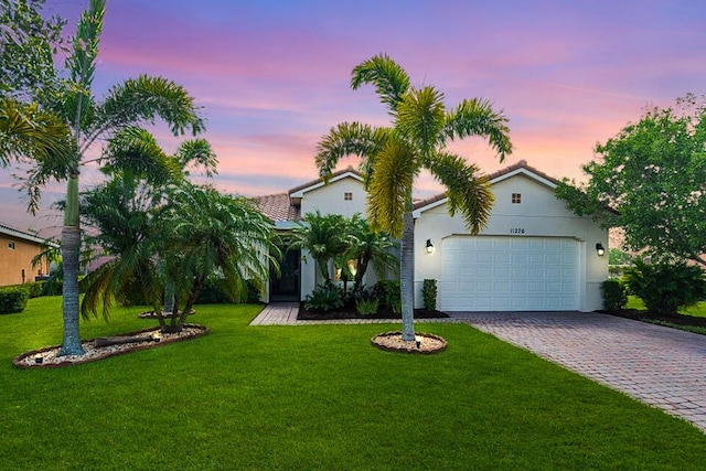 view of front facade with a garage and a lawn