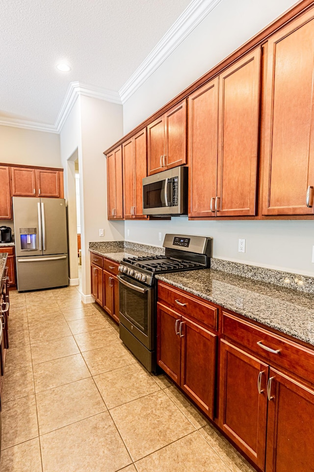 kitchen featuring stainless steel appliances, light stone counters, ornamental molding, a textured ceiling, and light tile patterned flooring