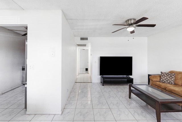 living room with a textured ceiling and ceiling fan