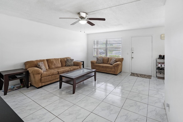 living room with ceiling fan and a textured ceiling