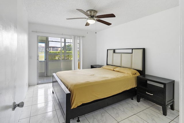 bedroom featuring ceiling fan, access to exterior, and a textured ceiling