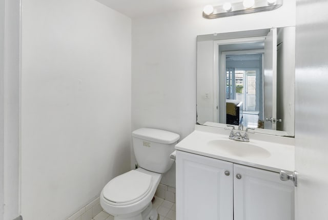 bathroom with tile patterned flooring, vanity, and toilet