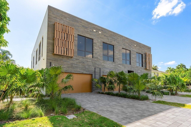 contemporary home featuring decorative driveway and a garage