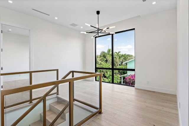 staircase featuring a notable chandelier, recessed lighting, baseboards, wood finished floors, and visible vents