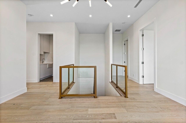 hallway with recessed lighting, an upstairs landing, wood finished floors, and visible vents