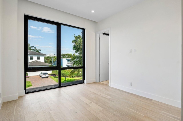 empty room with recessed lighting, baseboards, and light wood-type flooring