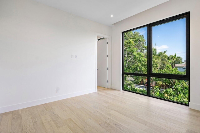 empty room featuring recessed lighting, baseboards, and wood finished floors