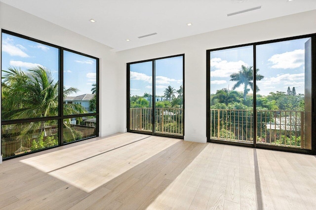 spare room featuring wood finished floors and visible vents