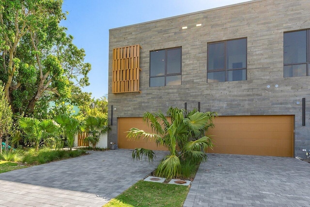 contemporary home with decorative driveway and a garage