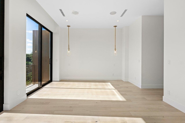 hall with baseboards, a wealth of natural light, and wood finished floors