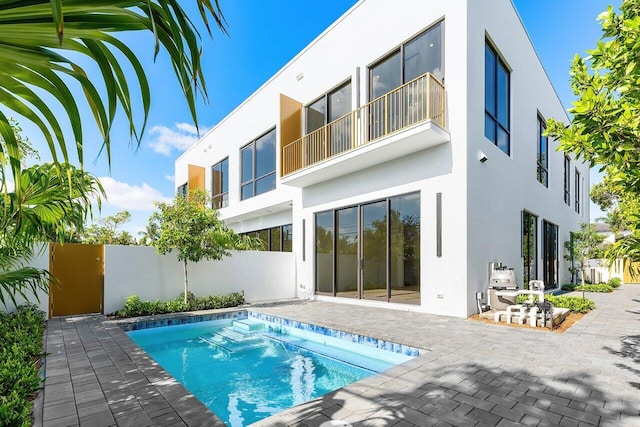 back of property featuring a fenced in pool, a patio area, and stucco siding