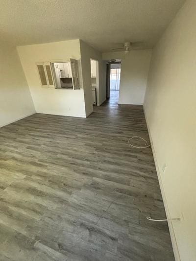 empty room with dark hardwood / wood-style flooring and a textured ceiling