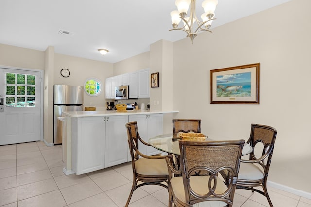 tiled dining space featuring a chandelier