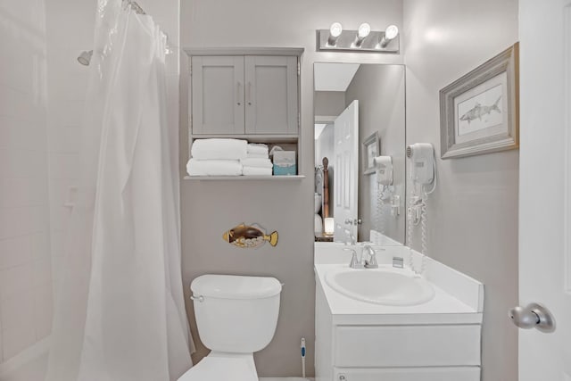 bathroom featuring toilet, vanity, and walk in shower