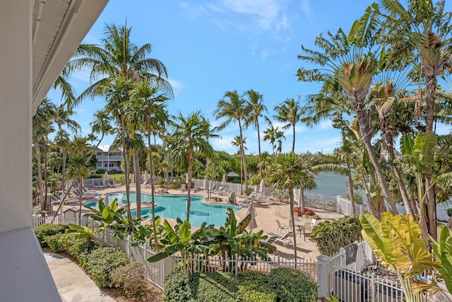 view of pool with a water view and a patio