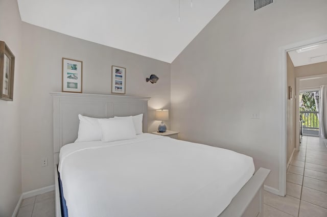 tiled bedroom featuring vaulted ceiling