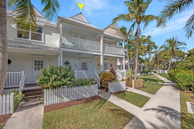 townhome / multi-family property with a front yard and a balcony