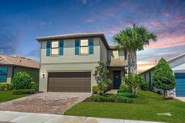 view of front of home featuring a garage and a yard