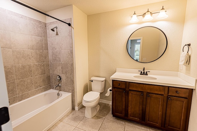 full bathroom featuring vanity, tile patterned flooring, toilet, and tiled shower / bath