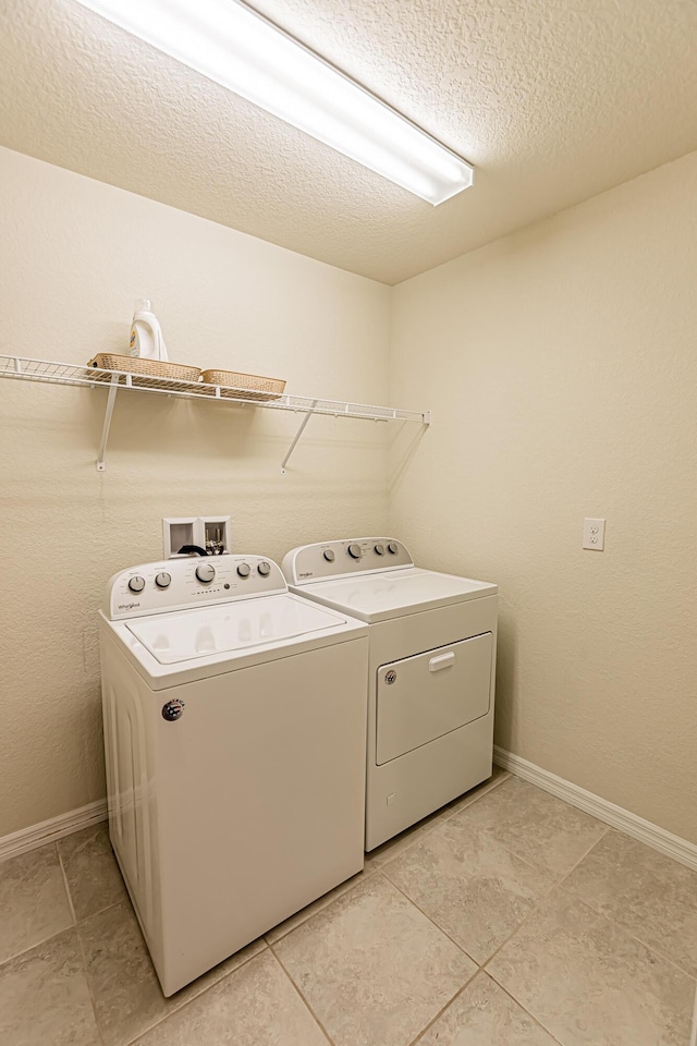 washroom featuring independent washer and dryer and a textured ceiling